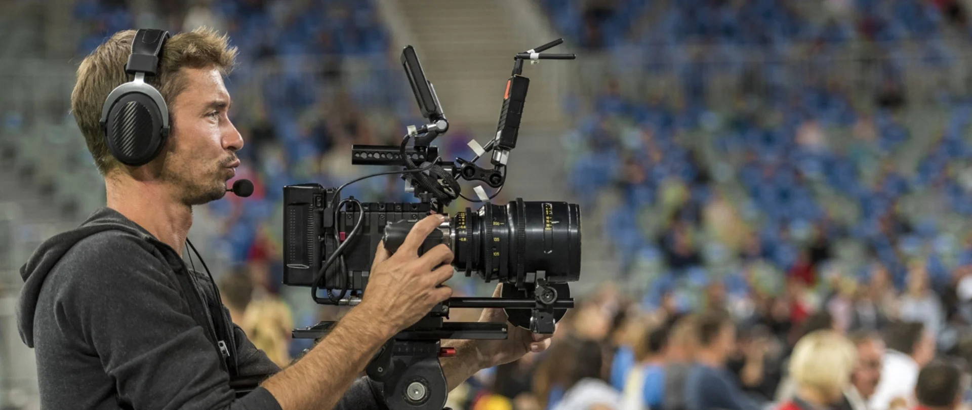 A Professional camera man capturing a live sports event highlighting managed services for efficient media production and coverage.