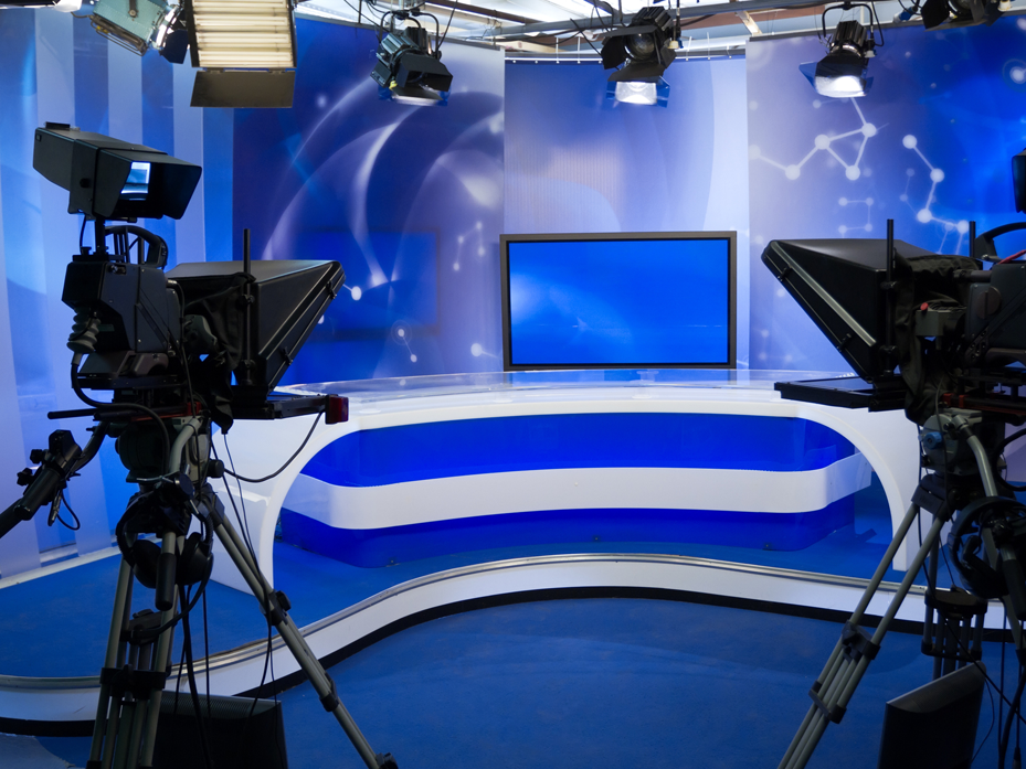 TV studio with cameras, lights, monitors for live broadcast production.